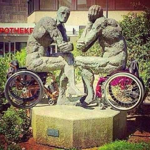 statue de deux hommes assis qui se font face en s'ignorant, sur des fauteuil roulant