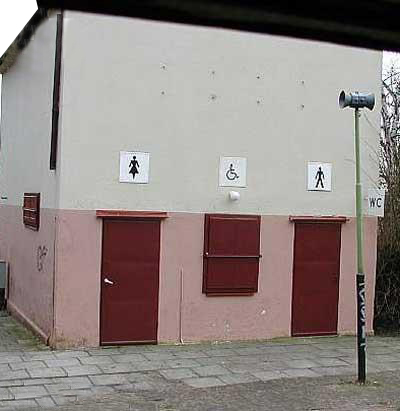 Une porte de WC public pour hommes d'un ct, pour femmes de l'autre... Et entre deux, une fentre marque de l'indication : Pour personne handicape !